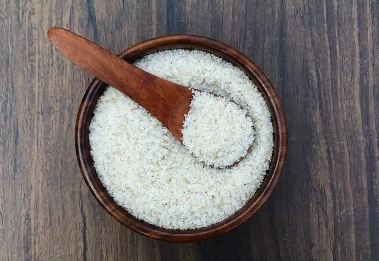 Isabgol (psyllium husk) in wooden bowl with spoon on rustic wooden background